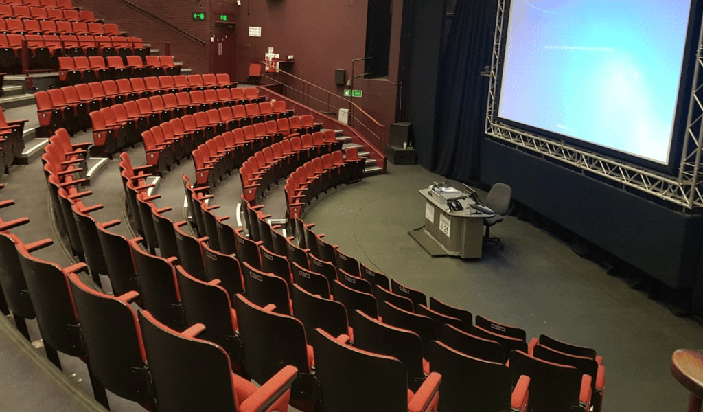 Empty Exeter Northcott Theatre with big projector screen on stage