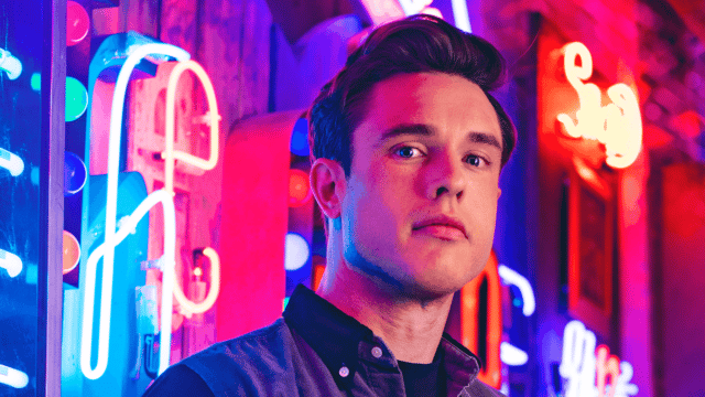 Image of Ed Gamble stood in front of bright neon signs