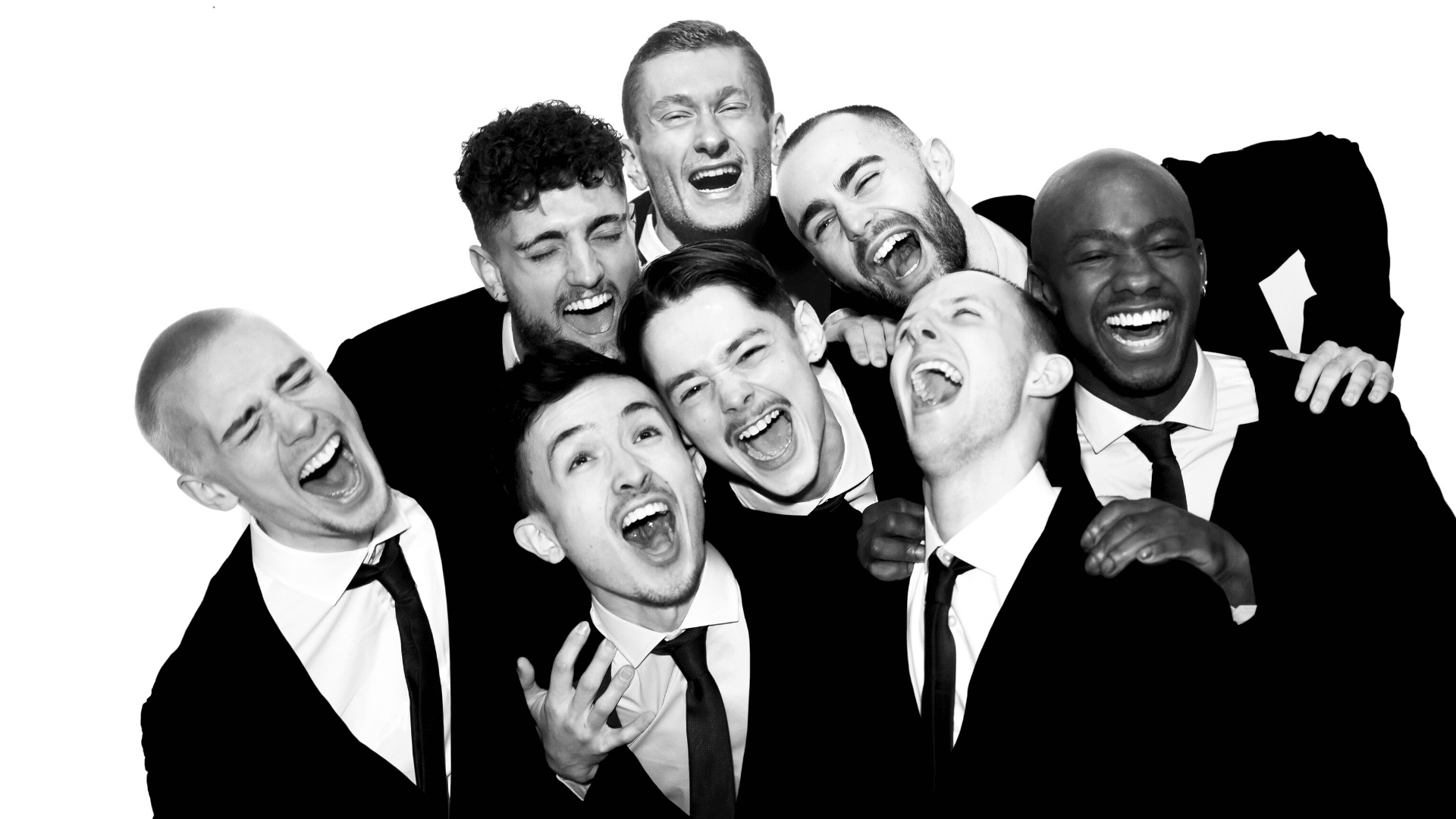A black and white photo of the BalletBoyz ensemble in sharp black suits