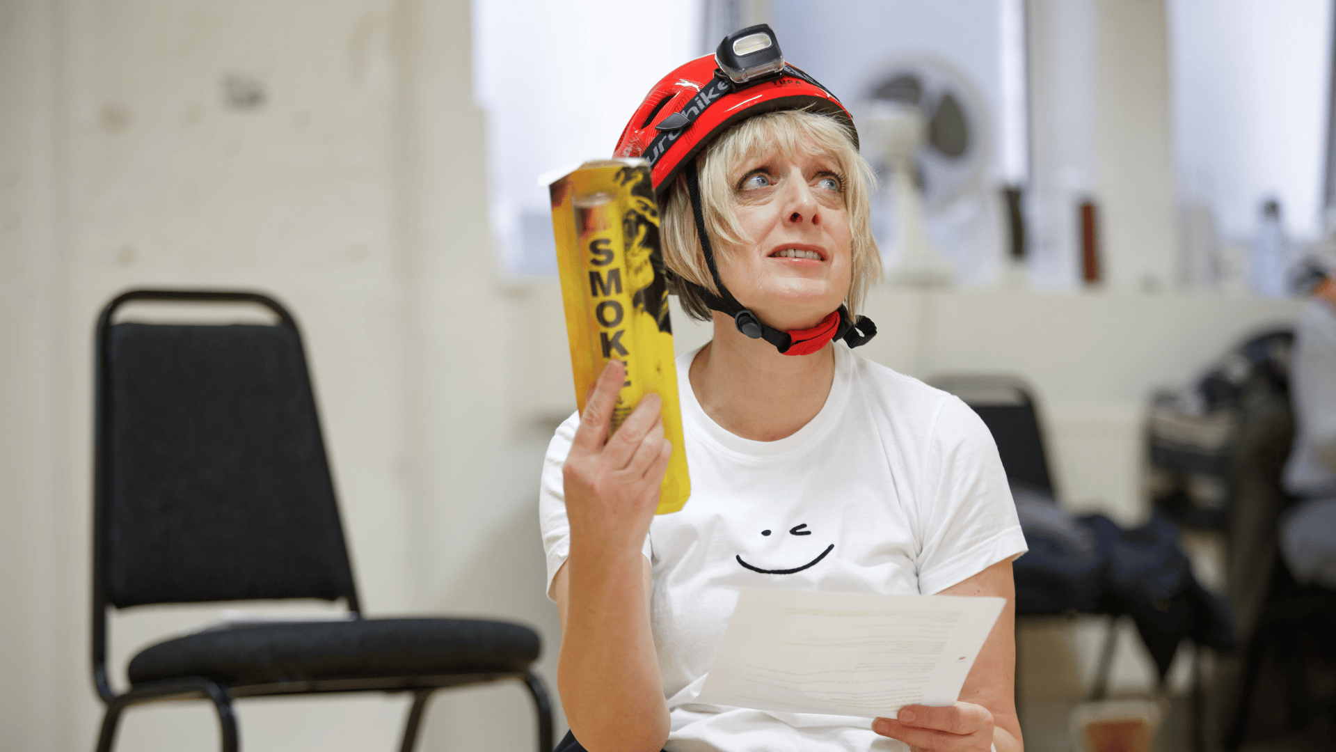 Sheila's Island Rehearsal image featuring Judy Flynn (Sheila) wearing a hard hat and holding a flare while looking confused