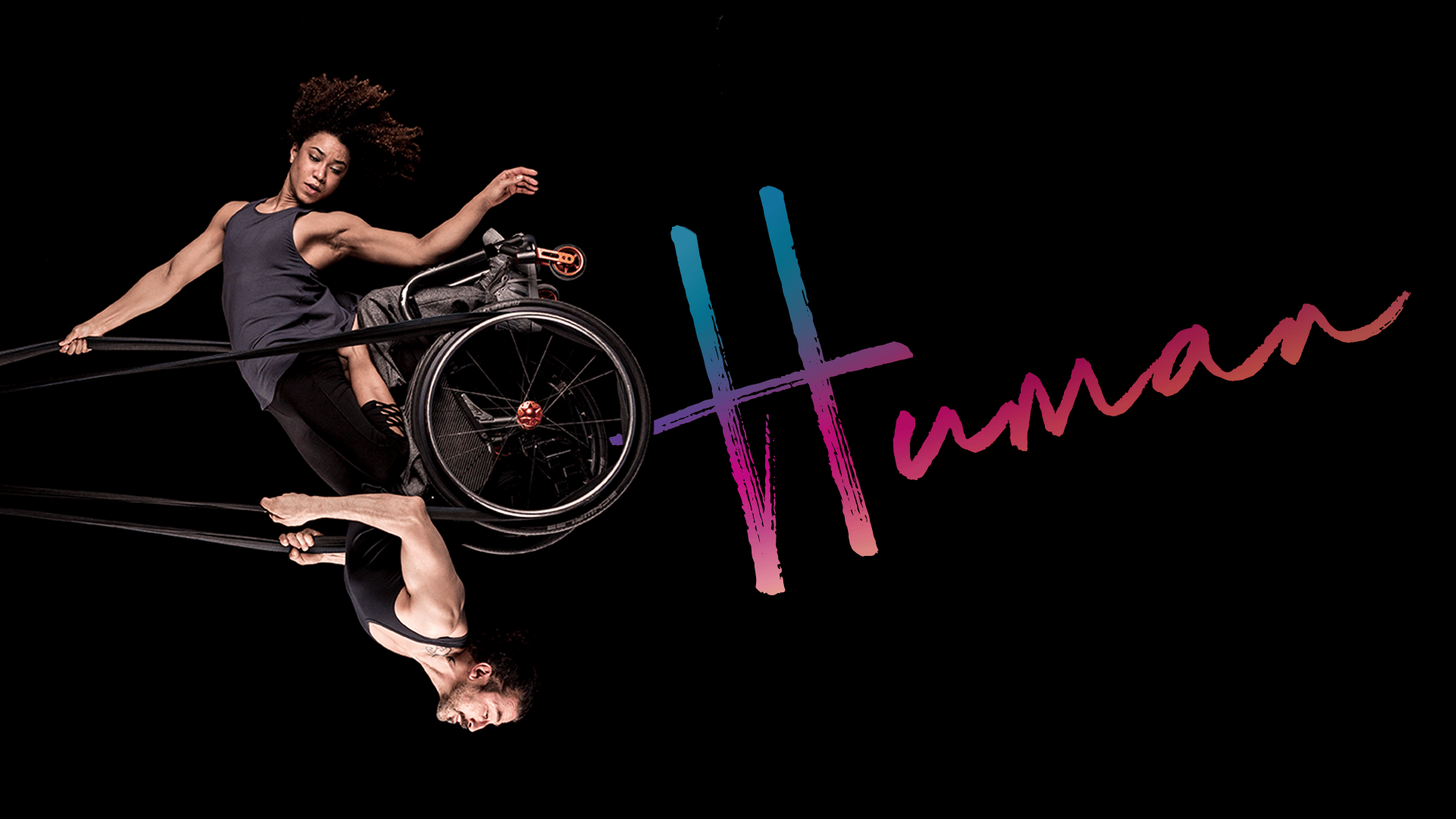 Human Artwork - two performers, one sitting in a wheelchair, swing on an aerial rope against a black background. Text reads: 'Human'.